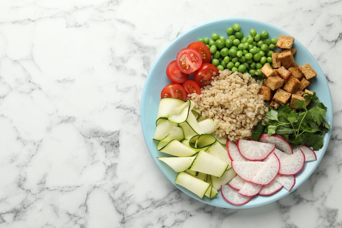 different healthy vegetarian food on white marble