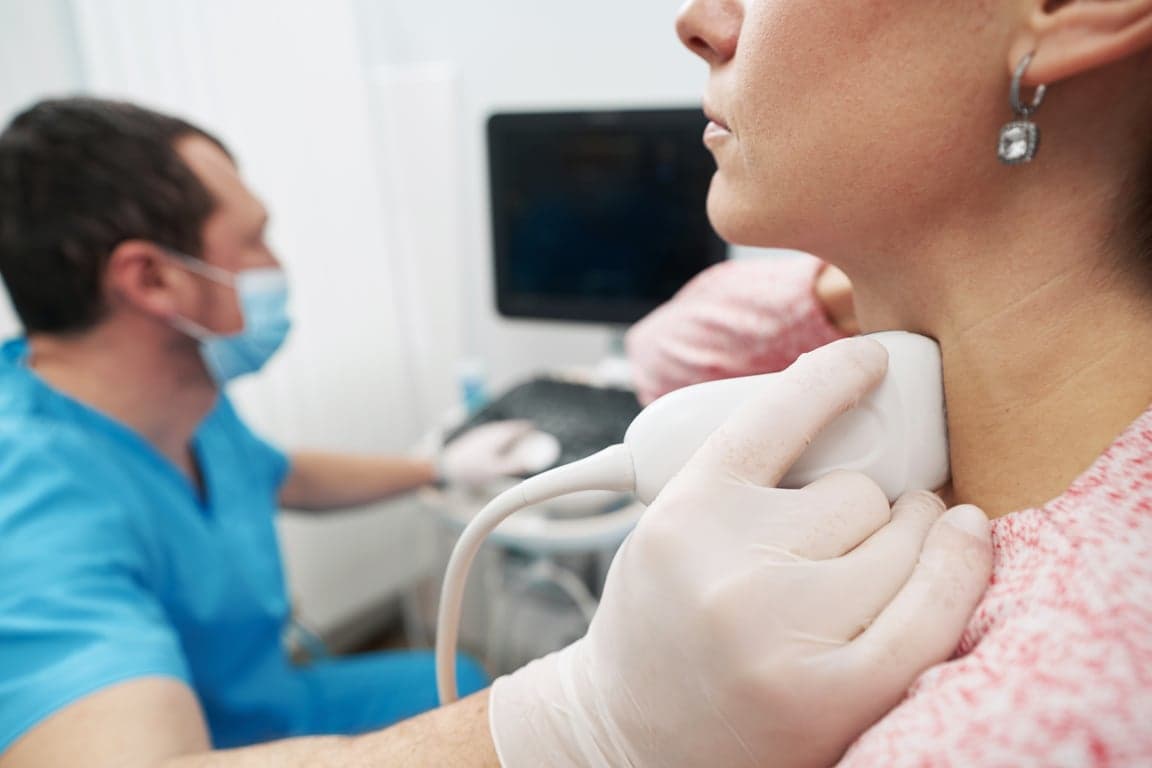 woman getting thyroid ultrasound at hospital clini