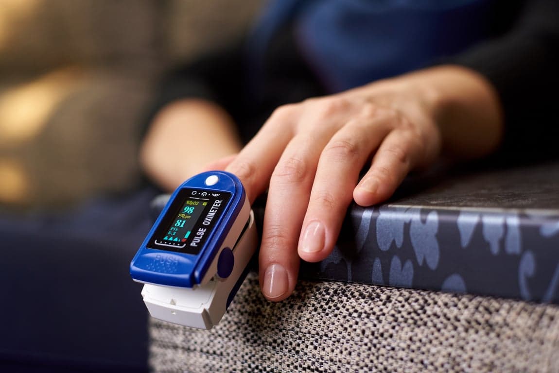 Fingertip pulse oximeter displaying a blood oxygen saturation (SpO2) reading of 98 percent