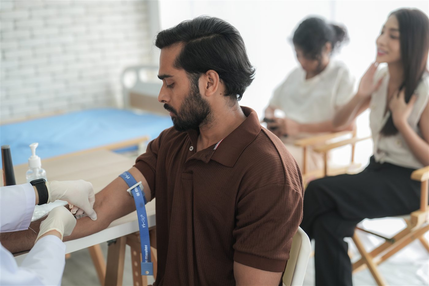 A nurse checks an employee's blood pressure during an on-campus screening