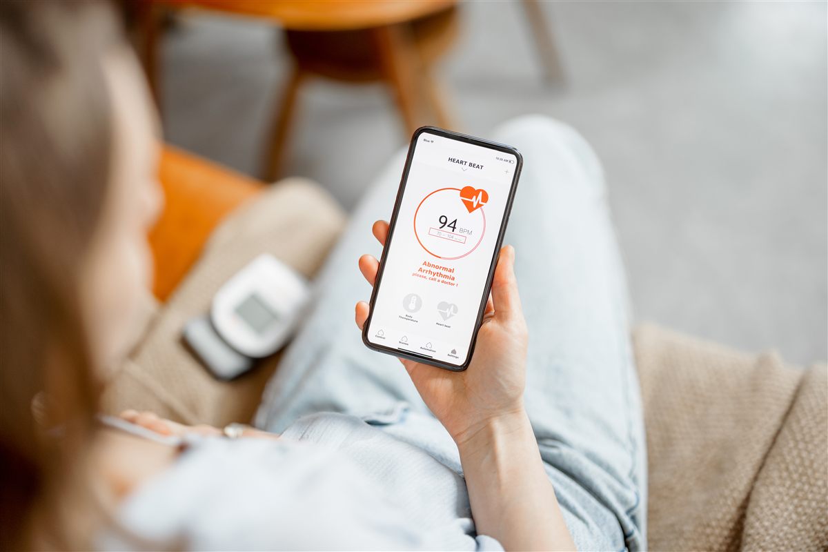 Woman checking a heartbeat reading on a mobile health app